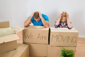 Frustrated Young Couple With Moving Boxes At Home